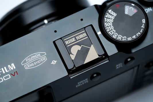 Hotshoe cover bergen & zon – "Rise High" gravure in zwart aluminium – berglandschap camera-accessoire voor Fujifilm X100VI, Sony, Nikon by Unseend