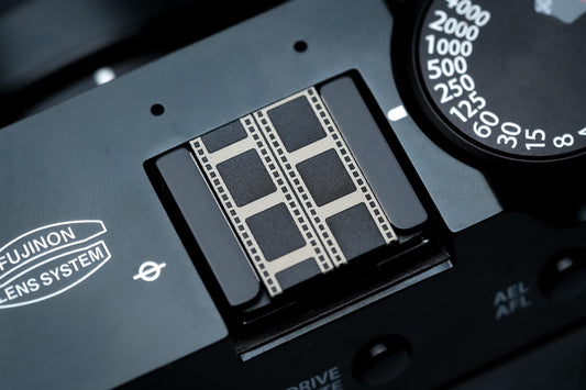 Hotshoe cover filmstrook gravure – zwart aluminium – voor Fujifilm X100VI & analoge camera’s by Unseend